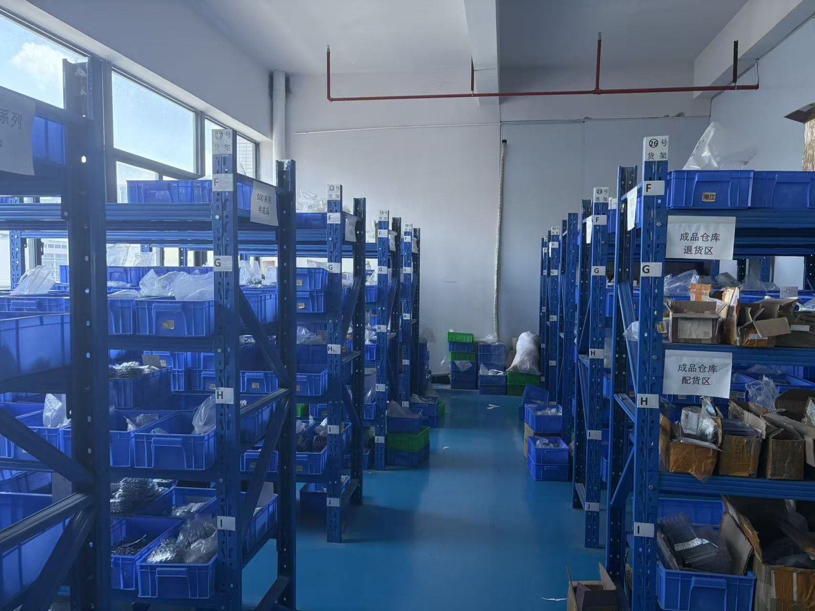 Organized warehouse with blue shelving units storing soldering tips ready for global shipment